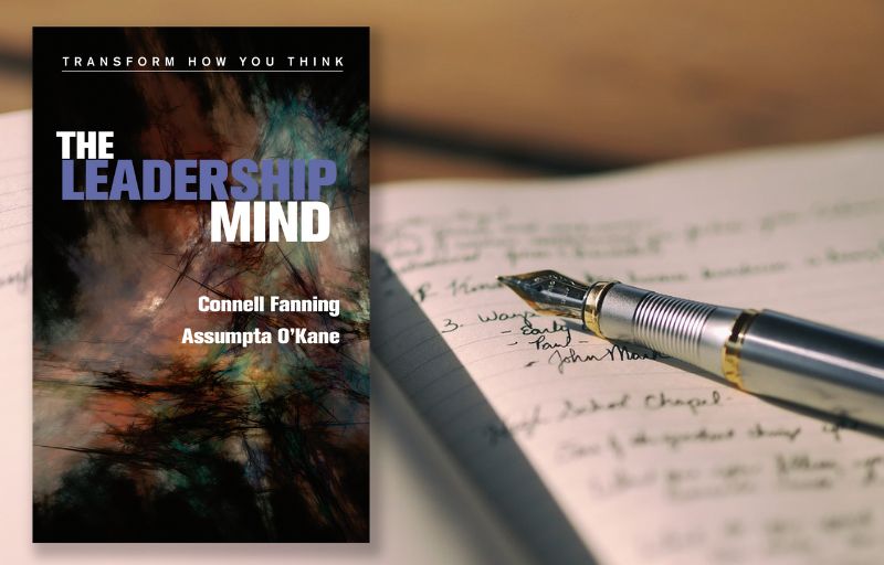 The leadership Mind book over background of notebook and pen.